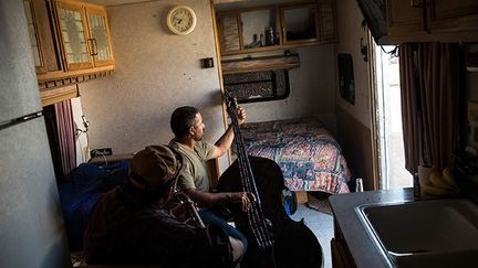 sont venus faire fortune dans la région. Ils ont laissé femmes et enfants en Arizona.
 
Ils vivent avec leurs deux autres frères dans leurs caravanes. Quand arrivent leur unique jour de repos de la semaine, ils aiment sortir leurs instruments de musique.
 
Pour éviter que la violence n’explose dans ces camps exclusivement masculins, alcool,  drogue et armes à feu sont interdits.  (Andrew Burton / Getty Images / AFP)