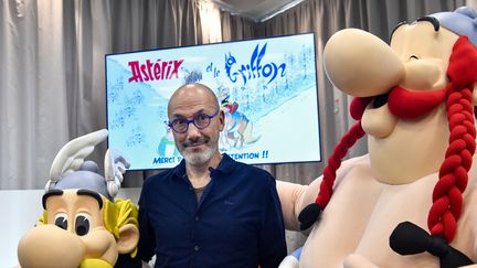 Jean-Yves Ferri, scénariste d'Asterix, entouré des personnages Asterix et Obelix lors de la présentation de l'album "Asterix et le Griffon", à Vanves (Hauts-de-Seine), le 11 octobre 2021. (ALAIN JOCARD / AFP)