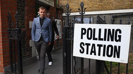 Des électeurs britanniques sortent d'un bureau de vote, le 8 juin 2017, à Londres (Royaume-Uni), aux premières heures des élections législatives anticipées. (JUSTIN TALLIS / AFP)