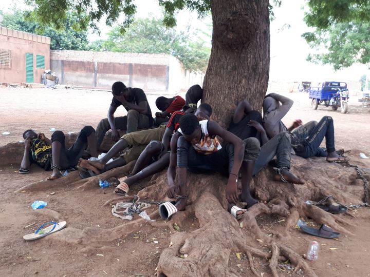 Une dizaine de voleurs, aux membres tuméfiés, sont enchaînés à un arbre sous un soleil de plomb. (Claude Guibal/ Radio France)