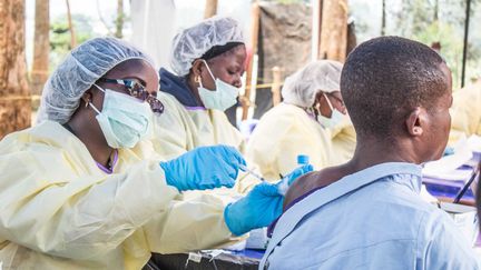 Une soignante administre un vaccin contre Ebola à un homme à&nbsp;Butembo, en République démocratique du Congo, le 27 juillet 2019. (JC WENGA / ANADOLU AGENCY / AFP)