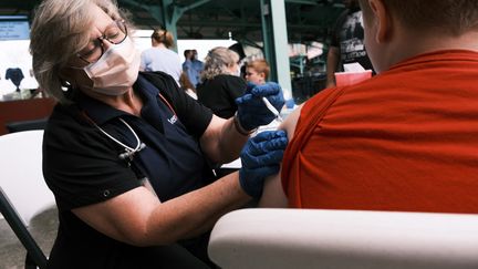 Une infirmière injecte une dose de vaccin contre le Covid-19 à un adolescent, le 5 août 2021, dans le&nbsp;Missouri, aux Etats-Unis. (SPENCER PLATT / GETTY IMAGES NORTH AMERICA / AFP)