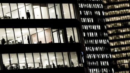 Des personnes travaillant dans les bureaux du quartier d'affaires de la Défense près de Paris (Covid-19), le 2 novembre 2020. Photo d'illustration. (ALAIN JOCARD / AFP)