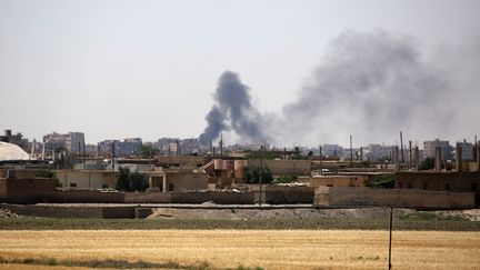 De la fumée s'échappe d'immeubles du quartier&nbsp;Mechleb à Raqqa (Syrie), le 7 juin 2017, utilisé comme point de départ pour de nouvelles opérations par les Forces démocratiques syriennes. (DELIL SOULEIMAN / AFP)