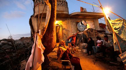  (Famille palestinienne devant sa maison endommagée par le conflit dans le sud de la bande de Gaza © MAXPPP)