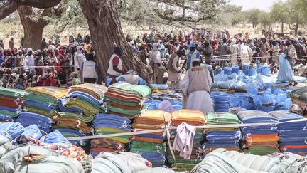 Des réfugiés soudanais attendent de recevoir des kits d'aide humanitaire préparés par l'Unicef, à Koufroun, au Tchad, le 30 avril 2023. (GUEIPEUR DENIS SASSOU / AFP)