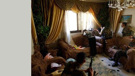 Aujourd’hui, ce sont des combattants de l’Armée syrienne libre qui occupent cette salle de séjour d'une maison familiale à Alep. Un des soldats tire par la fenêtre sur un sniper. 

Cette maison auparavant était occupée par trois militaires de l’armée régulière d’Assad. Ils y furent tués.

En août 2012, Goran Tomasevic réalise pour l’agence Reuters, ce reportage à Alep. (Goran Tomasevic / Reuters)