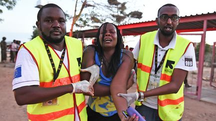 Les secours aident une &eacute;tudiante bless&eacute;e durant l'attaque d'islamistes somaliens shebabs contre l'universit&eacute; de Garissa, au Kenya, le 2 avril 2015. (CARL DE SOUZA / AFP)