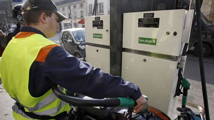 Un pompiste parisien sert un motard, le 14 mars 2012. Les prix de certaines stations-service ont pass&eacute; le seuil des 2 euros par litre. (REMY DE LA MAUVINIERE / AP / SIPA)