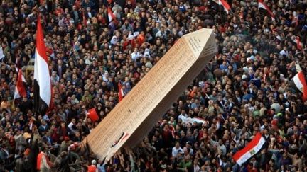 Les révolutionnaires égyptiens portent une obélisque avec les noms des morts de 2011, place Tahrir, le 25/01/12 (AFP/MAHMUH HAMS)