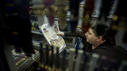 Un homme lit un journal à Moscou (illustration). (NATALIA KOLESNIKOVA / AFP)