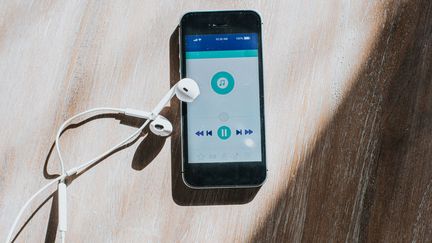 Image d'illustration d'un smartphone en train de jouer de la musique sur une application de streaming musical. (CATHERINE FALLS COMMERCIAL / MOMENT RF / GETTY IMAGES)