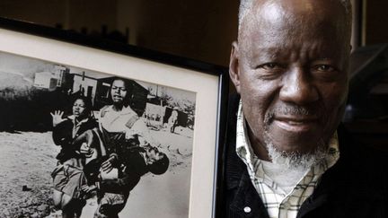 Le photographe Sam Nzima pose en 2011 avec sa photo icônique prise durant le soulèvement de Soweto en 1976.
 (Denis Farrell/AP/SIPA)