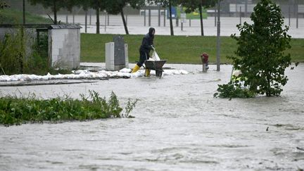 Un habitant construit une protection contre les inondations lors de fortes pluies à Neulengbach, dans le nord-est de l'Autriche, le 15 septembre 2024. (HELMUT FOHRINGER / APA)