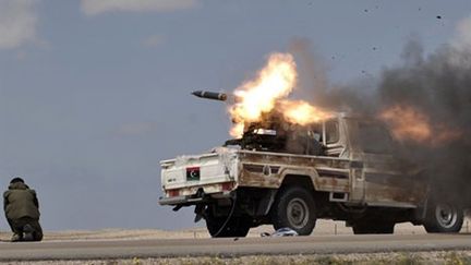 Les rebelles libyens tirent une rockette sur les forces de Kadhafi à environ 20 kms de Brega, le 31 mars 2011. (AFP PHOTO / ARIS MESSINIS)