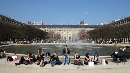 Des Parisiens profitent des températures exceptionnellement clémentes au jardin du Palais-Royal, le 26 mars 2017. (LUDOVIC MARIN / AFP)