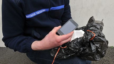 Un surveillant montre un t&eacute;l&eacute;phone portable jet&eacute; par-dessus les murs de la prison de Sequedin (Nord), le 16 avril 2013. (  MAXPPP)