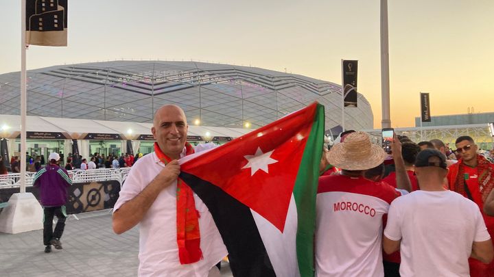 Un supporter brandit le drapeau de la Jordanie à côté de fans marocains avant le huitième de finale de la Coupe du monde entre le Maroc et l'Espagne au stade Al-Thumama de Doha, le 6 décembre 2022. (Denis Ménétrier)