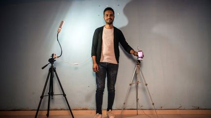 Mohamed Abdelkader, 29 ans, propriétaire égyptien de téléphones mobiles, pose avec son smartphone dans son magasin d'Al-Noubaria, dans le gouvernorat de Beheira, au nord-est de la capitale Le Caire, le 8 novembre 2018. Mohamed utilise son smartphone pour suivre les réseaux sociaux.  (KHALED DESOUKI / AFP)