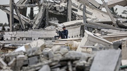 Un Palestinien au milieu des débris d'immeubles dans le camp de réfugiés de Maghazi, dans le centre de la bande de Gaza, le 27 février 2024. (AFP)