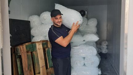 Le gérant de la fabrique de glaçons, Damien Friley, sac de glace sur l'épaule. (FARIDA NOUAR / RADIO FRANCE)