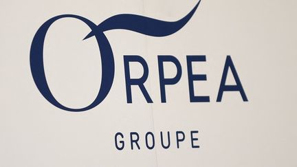 Le logo d'Orpéa affiché lors d'une assemblée générale du groupe à Paris, le 28 juillet 2022. (JULIEN DE ROSA / AFP)