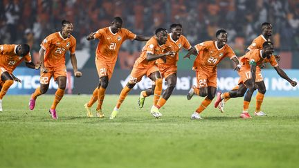 La joie des Ivoiriens, qualifiés pour les quarts de finale de la CAN après leur victoire aux tirs au but face au Sénégal, le 29 janvier 2024 à Yamoussoukro (Côte d'Ivoire). (KENZO TRIBOUILLARD / AFP)