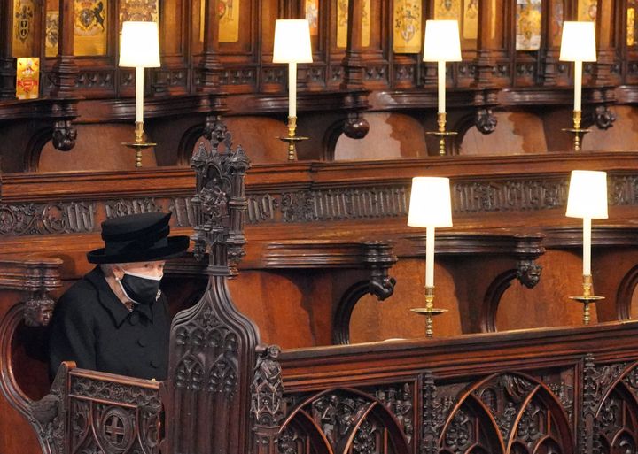 La cérémonie de funérailles du prince Philip était limitée à 30 personnes en raison de l'épidémie de Covid-19. La reine, masquée, se trouvait donc un peu esseulée&nbsp;dans la chapelle Saint-George. (JONATHAN BRADY / AFP)