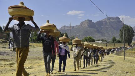 Des Ethiopiens portent des corbeilles d'aliments traditionnels tissées à la main pour se rendre cérémonieusement à une réunion de réconciliation dans le district d'Irob, dans le nord de l'Ethiopie, près de la frontière avec l'Erythrée, le 23 octobre 2019. (MICHAEL TEWELDE / AFP)