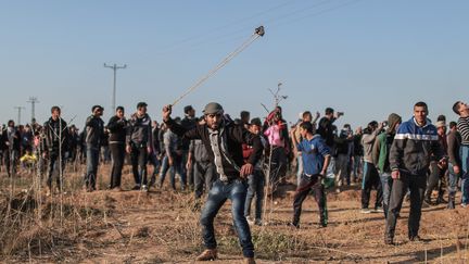 Des Palestiniens lancent des pierres contre les forces de sécurité israéliennes lors d'un rassemblement de protestation, à Gaza, le 8 décembre 2017. (ALI JADALLAH / AFP)