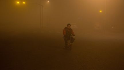 Un homme roule dans le smog à Pékin (Chine) le 20 décembre 2016. (CHINA STRINGER NETWORK)