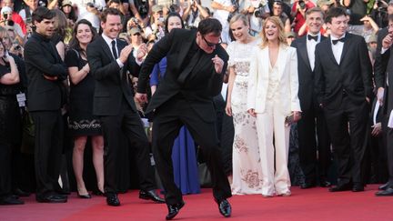 Sur le tapis rouge, Quentin Tarantino fait le show ! Une petite danse avant la projection d'Inglorious Basterds, devant l'équipe du film hilare. (FRANCOIS GUILLOT / POOL)