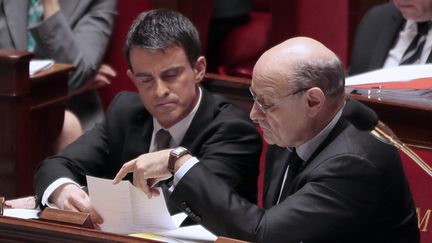 Le Premier ministre, Manuel Valls, &eacute;change avec son ministre charg&eacute; des Relations avec le Parlement, Jean-Marie Le Guen, le 16 avril 2014, dans l'h&eacute;micycle. (JACQUES DEMARTHON / AFP)