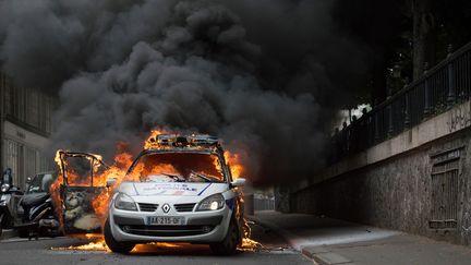 La voiture de police&nbsp;attaquée et incendiée, en marge d'une manifestation contre "la haine anti-flic" organisée à Paris, le 18 mai 2016. (CYRIELLE SICARD / AFP)