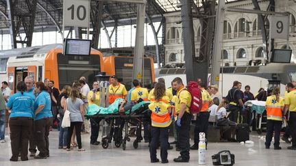 Des secouristes portent assistance aux personnes blessées lors de l'accident de train à Barcelone (Espagne), le 28 juillet 2017. (JOSEP LAGO / AFP)