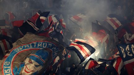 Les supporters parisiens agitent des drapeaux avant le match entre le PSG et le RC Strasbourg Alsace au stade du Parc des Princes, à Paris le 19 octobre 2024. (FRANCK FIFE / AFP)