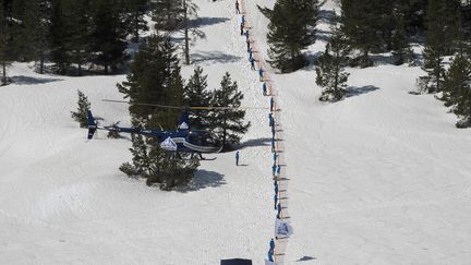 Des militants d'extrême droite dressent une barrière en plastique pour contrôler le passage des migrants entre l'Italie et la France, samedi 21 avril à Nevache (Hautes-Alpes). (ROMAIN LAFABREGUE / AFP)