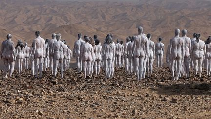 Plusieurs centaines de personnes peintes en blanc posent nues pour le photographe américain Spencer Tunick, le 17 octobre 2021 en Israël, au bord de la Mer morte menacée d'assèchement. (MENAHEM KAHANA / AFP)