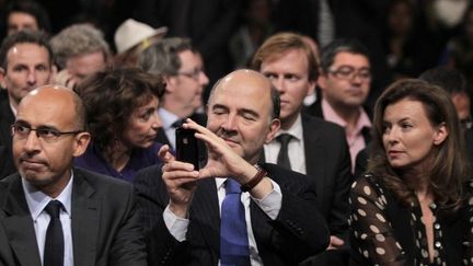 Pendant la campagne présidentielle, Pierre Moscovici (avec Valérie Trierweiler et Harlem Désir) sort son iPhone lors d’un meeting. (JOEL SAGET / AFP)