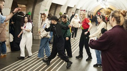 Des jeunes femmes improvisent des pas de danse après s'être réfugiées dans le métro de Kiev (Ukraine) en raison d'une alerte aérienne, le 31 décembre 2022. (DANYLO ANTONIUK / ANADOLU AGENCY / AFP)