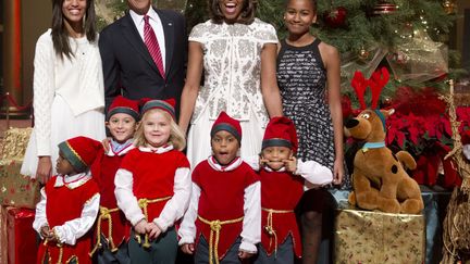 Le pr&eacute;sident am&eacute;ricain Barack Obama (2e G), son &eacute;pouse Michelle et ses deux filles posent pour une photo de No&euml;l en compagnie d'enfants d&eacute;guis&eacute;s en elfes, Washington (Etats-Unis), le 15 d&eacute;cembre 2013. (SAUL LOEB / AFP)