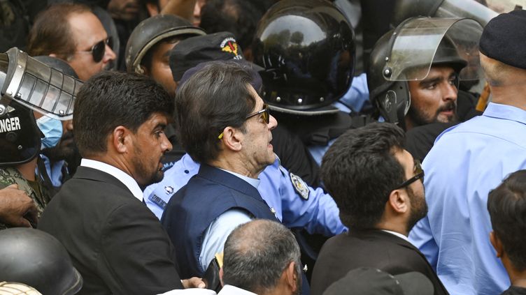 Police officers escort former Pakistani Prime Minister Imran Khan as he arrives at the High Court in Islamabad on May 12, 2023. (AAMIR QURESHI / AFP)