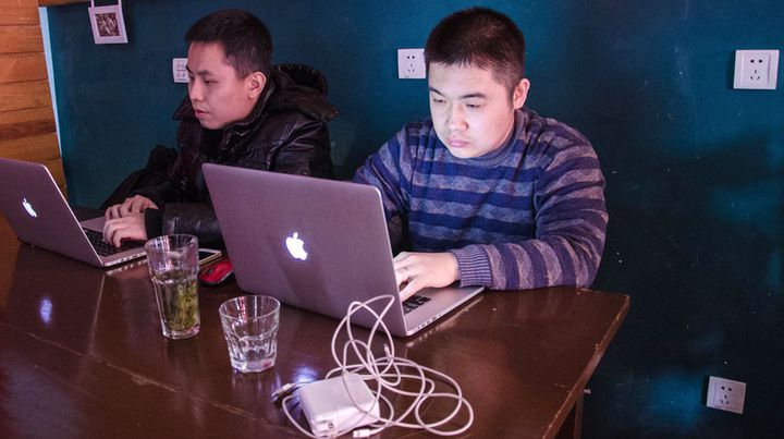 Zhang Bin (&agrave; gauche) et Wang Jun (&agrave; droite) dans le caf&eacute; qui leur sert de bureau,&nbsp;&nbsp;le 21 janvier 2014 &agrave; P&eacute;kin (Chine). (THOMAS BAIETTO / FRANCETV INFO)