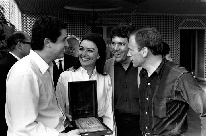 Le réalisateur Claude Lelouch célèbre sa palme d'or pour "Un homme et une femme" avec ses acteurs Anouk Aimée, Pierre Barouh et Jean-Louis Trintignant, en mai 1976 à Cannes. (JEAN-PIERRE BONNOTTE / GAMMA-RAPHO)