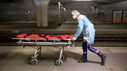 Un soignant&nbsp;prépare le brancard pour&nbsp;un patient atteint du Covid-19 dans un TGV médicalisé, en gare de Paris-Austerlitz, le 1er avril 2020. (THOMAS SAMSON / AFP)