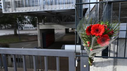 Un bouquet de fleurs attaché à l'entrée du collège de Lucas, qui s'est suicidé le 7 janvier 2023. (FREDERICK FLORIN / AFP)