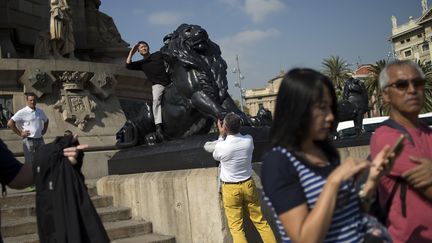 Des touristes visitent le monument dédié à Christophe Colomb à Barcelone, le 13 octobre 2017. (JORGE GUERRERO / AFP)