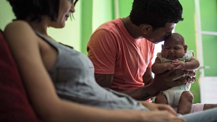 Matheus Lima et Kleisse Marcelina avec leur bébé de deux mois souffrant de microcéphalie, le 28 janvier 2016, à Salvador (Brésil).&nbsp; (CHRISTOPHE SIMON / AFP)