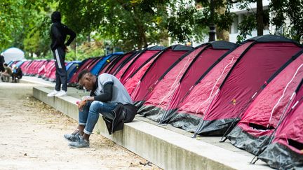 Un mineur isolé devant des tentes installées par des associations d'aide aux migrants, le 30 juin 2020 à Paris. (XOS? BOUZAS / HANS LUCAS)