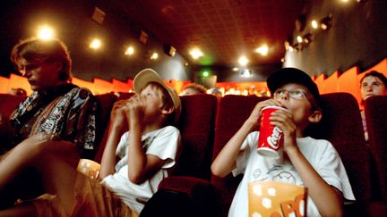 Des enfants assistent à la projection d'un film, le 26 juin 2005 à Lyon. (FRED DUFOUR / AFP)